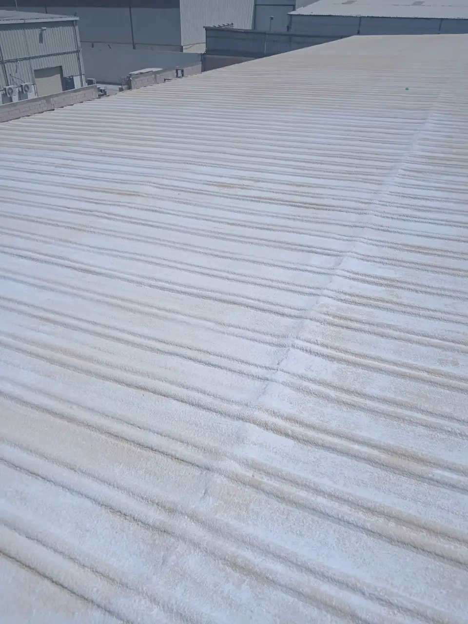 سقف معدني واسع مغطى بعزل فوم أبيض
