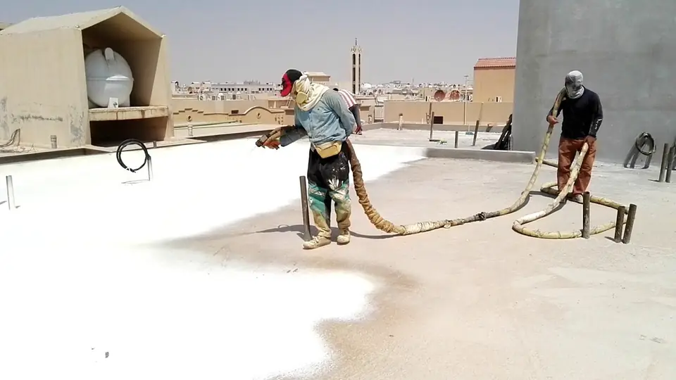 فنيون يرشون فوم البولي يوريثان على سطح خرساني في الرياض