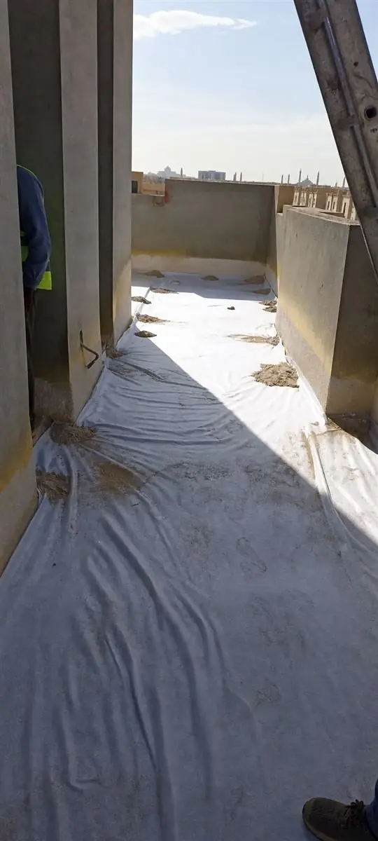 Geotextile layer laid on a roof walkway before the protective coat